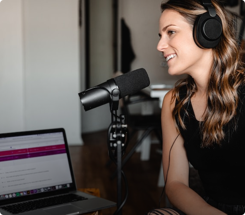 Woman speaking into a podcast microphone