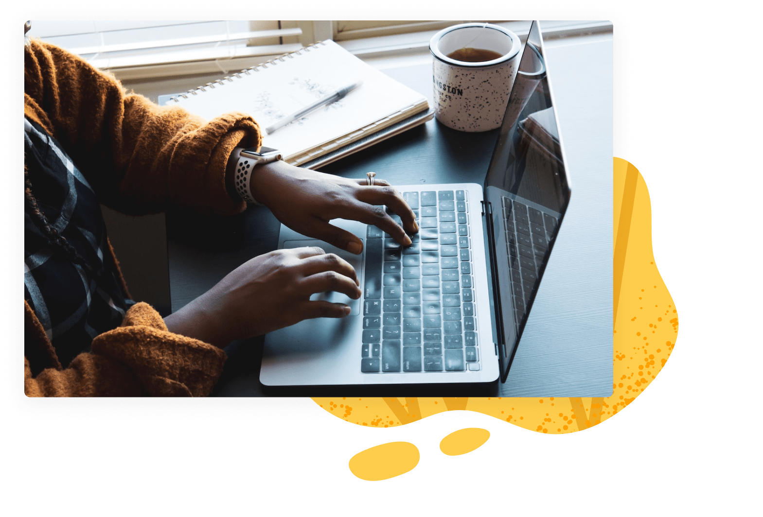 Hands typing on laptop on top of table